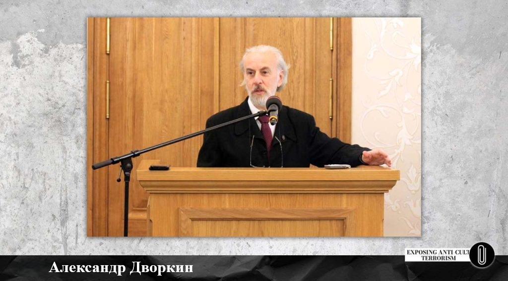 Александр Дворкин за кафедрой у микрофона читает лекцию